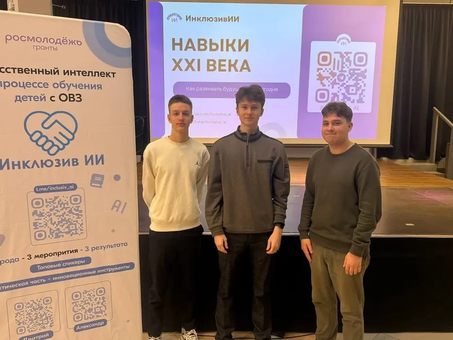Dmitrii and two teammates on stage at an InclusiveAI education event