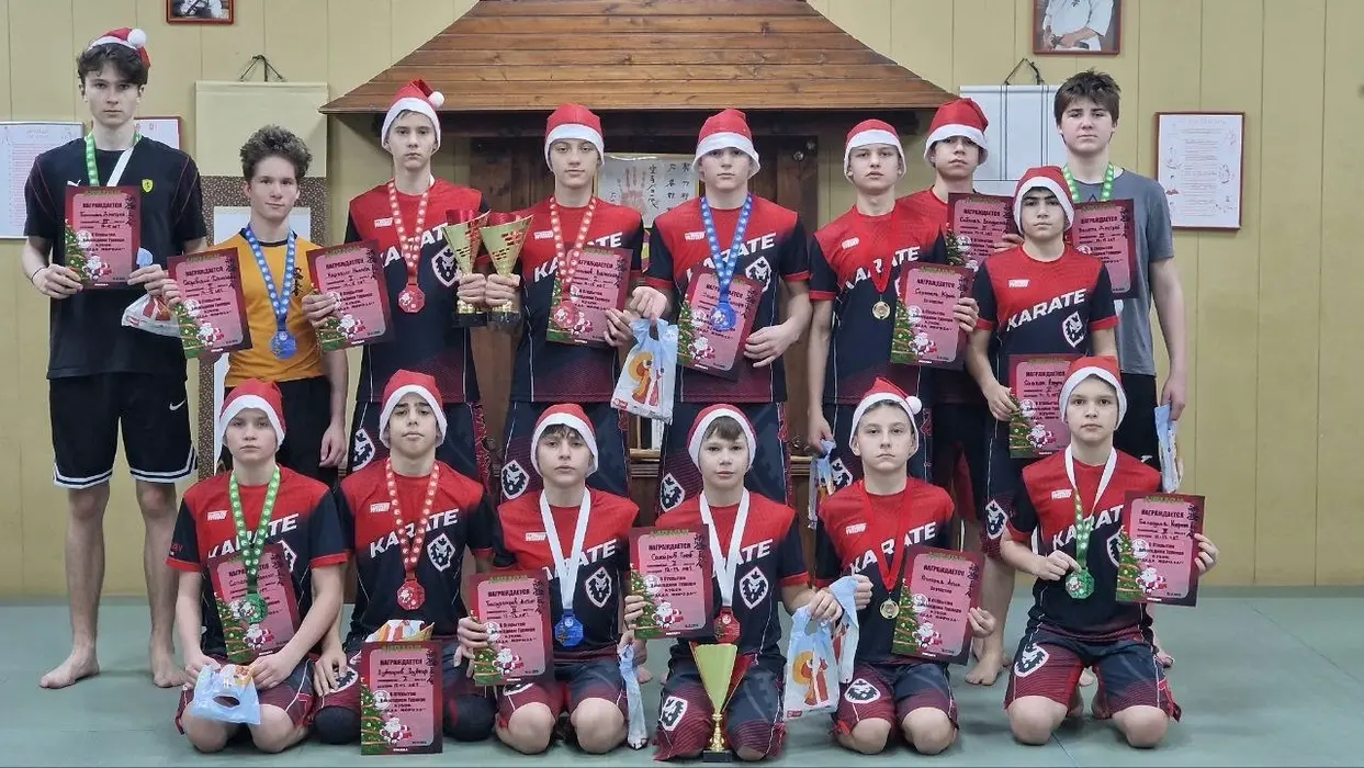 Karate team in red uniforms and santa hats with medals and certificates
